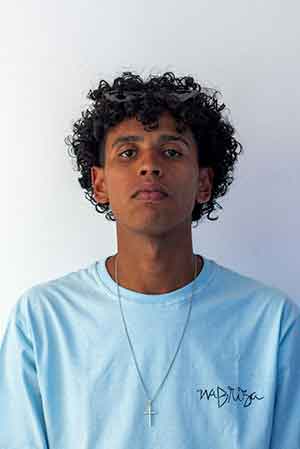 Young man with curly hair wearing a light blue shirt