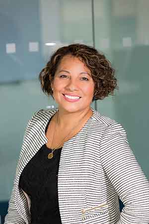 Woman with curly hair wearing a striped blazer