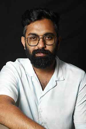 Man with glasses and a beard wearing a white shirt